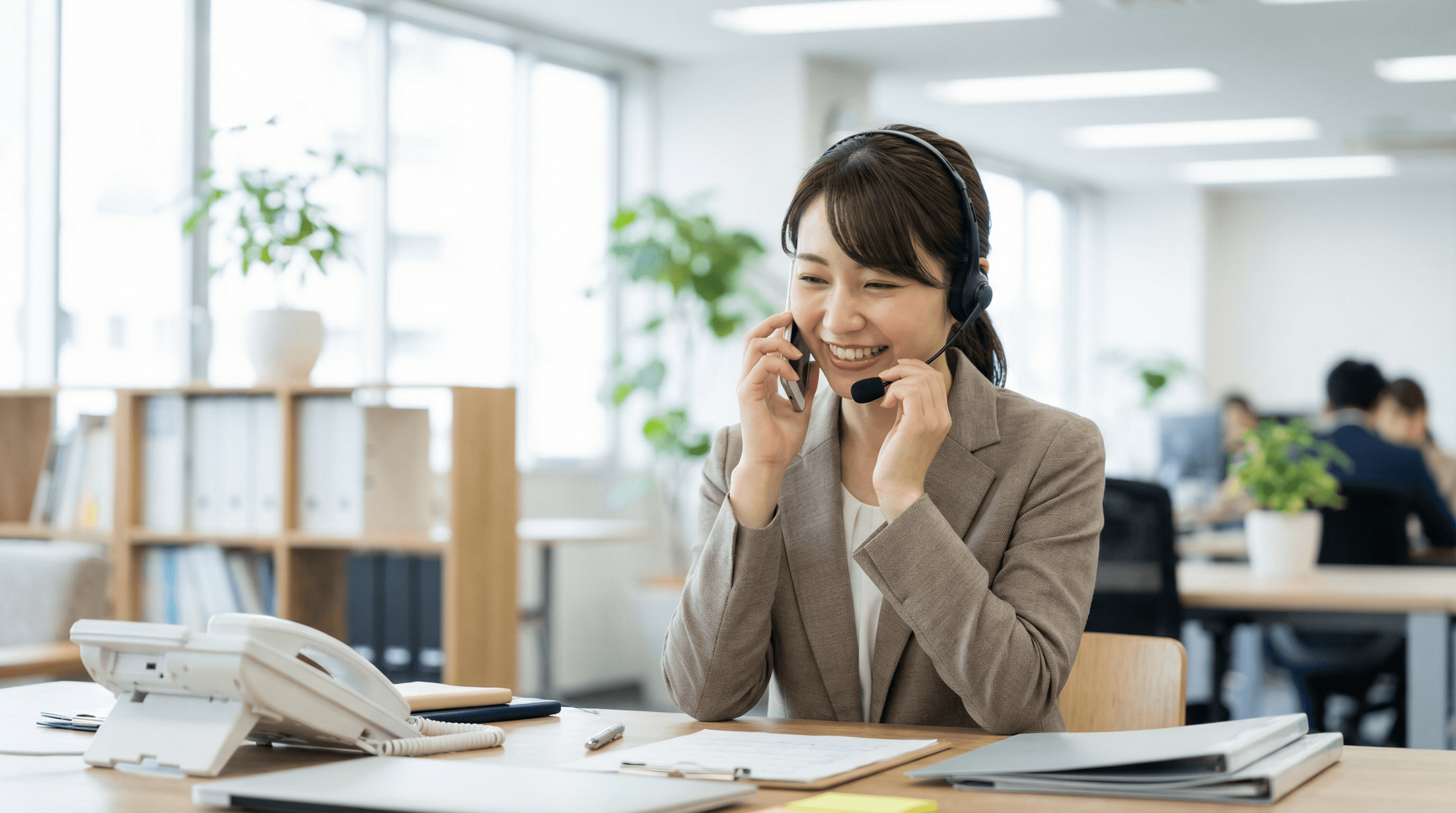 笑顔で電話対応する便利屋こころのスタッフ